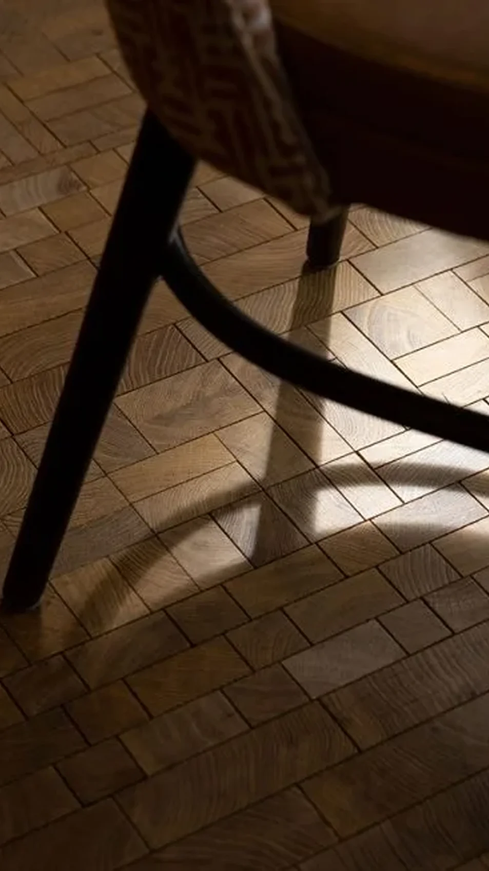 A Cube endgrain oak floor, a chair standing on it in low light